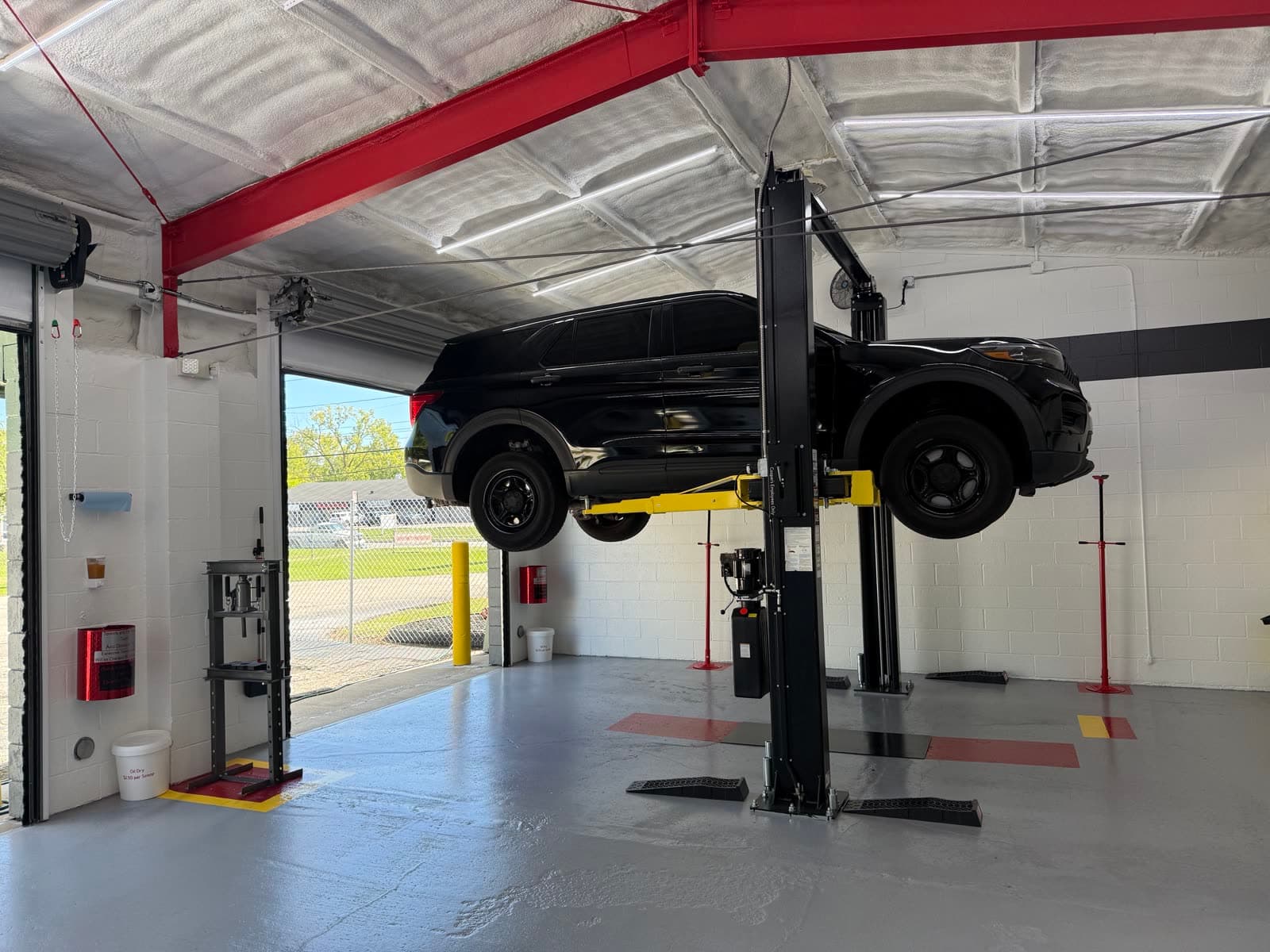 An SUV raised on the 2-post lift in a Coopers Garage bay